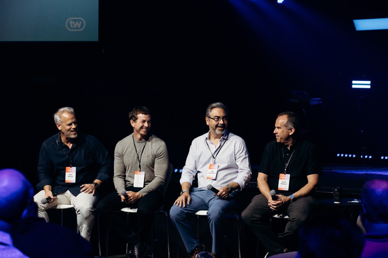 Four panelists on a conference stage