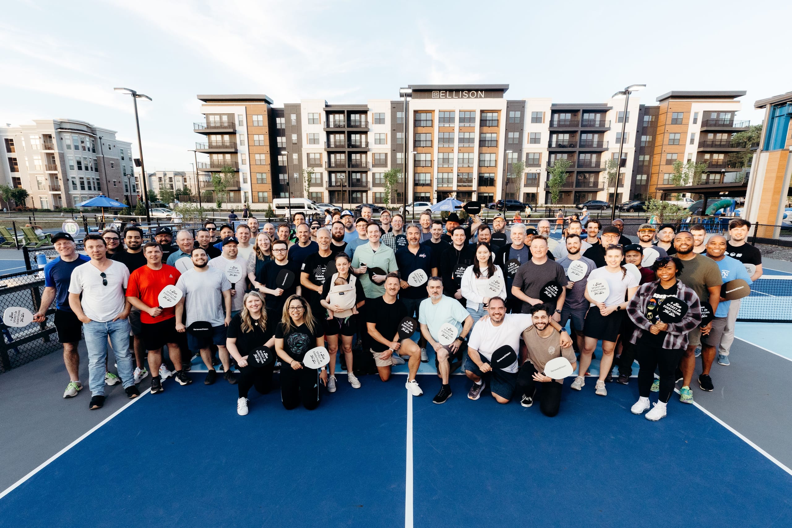 Team photo on a pickleball court at a company outing