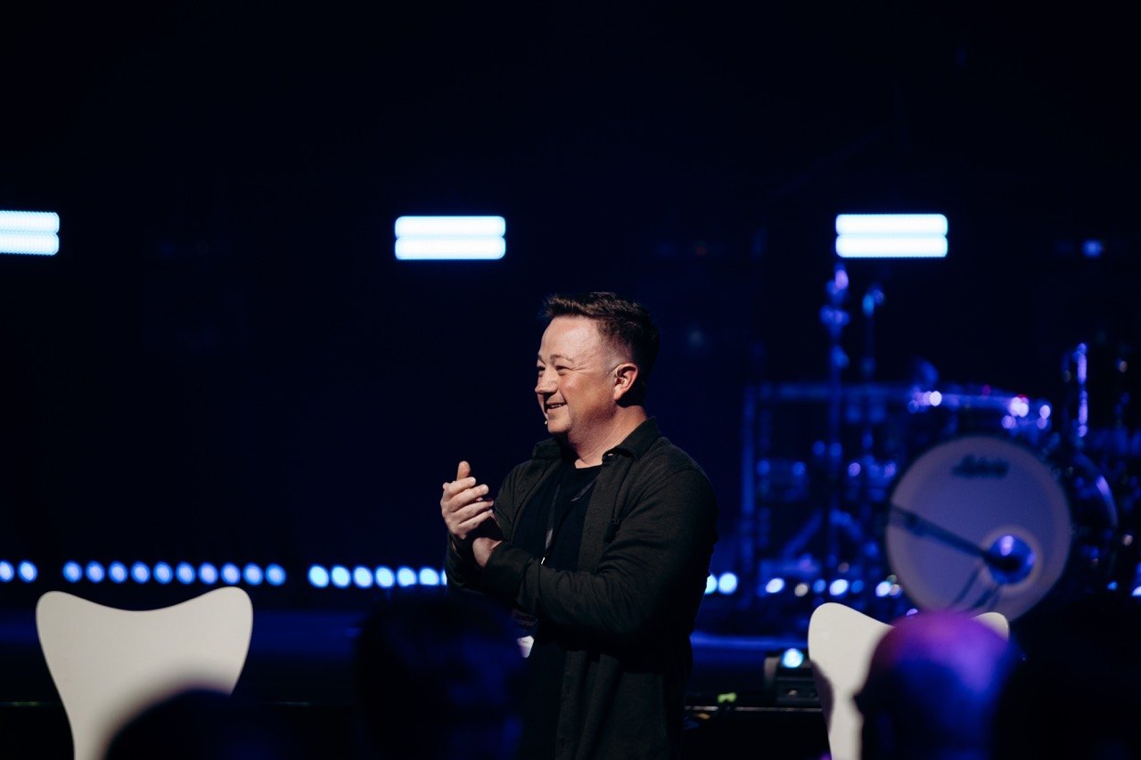 Speaker with a microphone on a dark stage