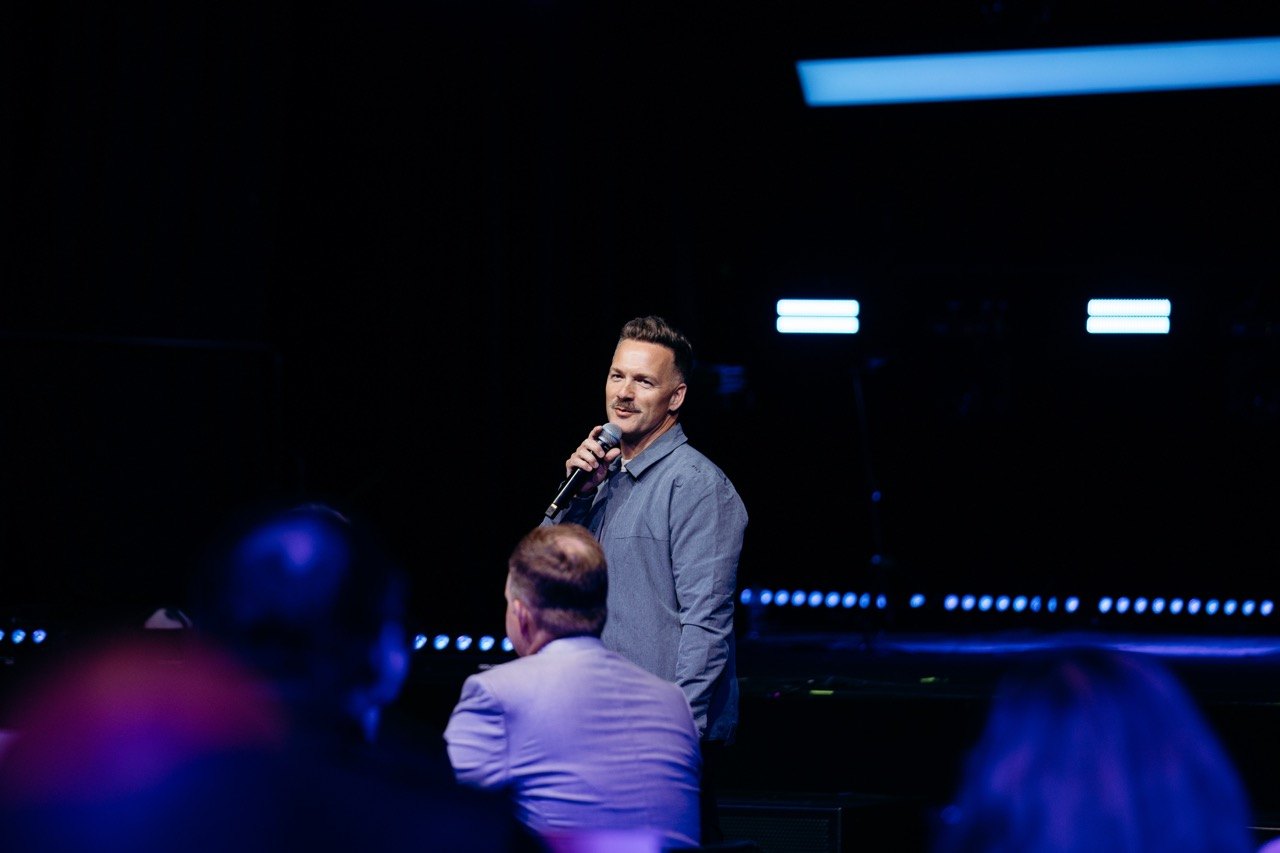 Presenter on stage in blue light