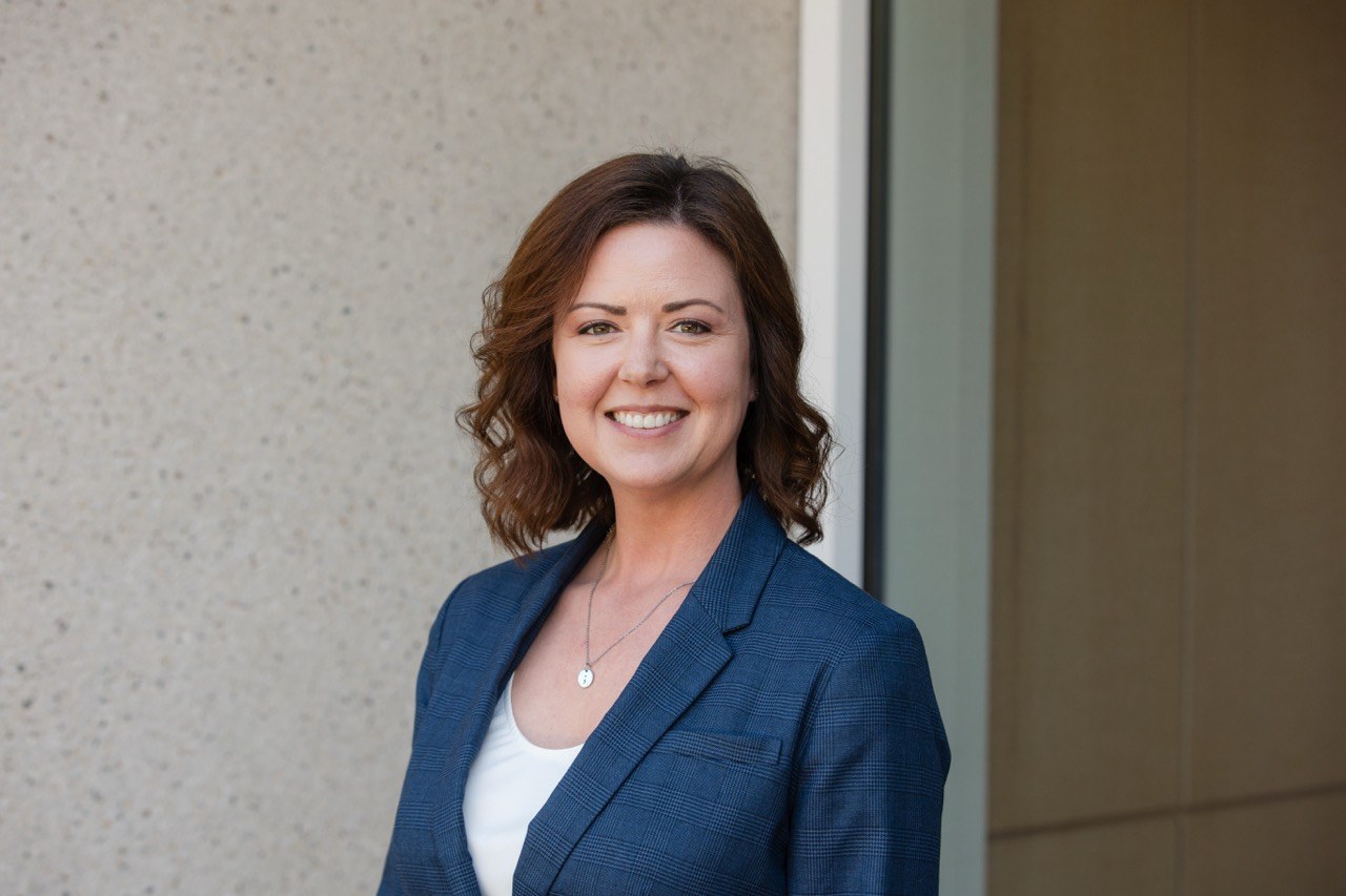 Headshot of a woman in a blue blazer