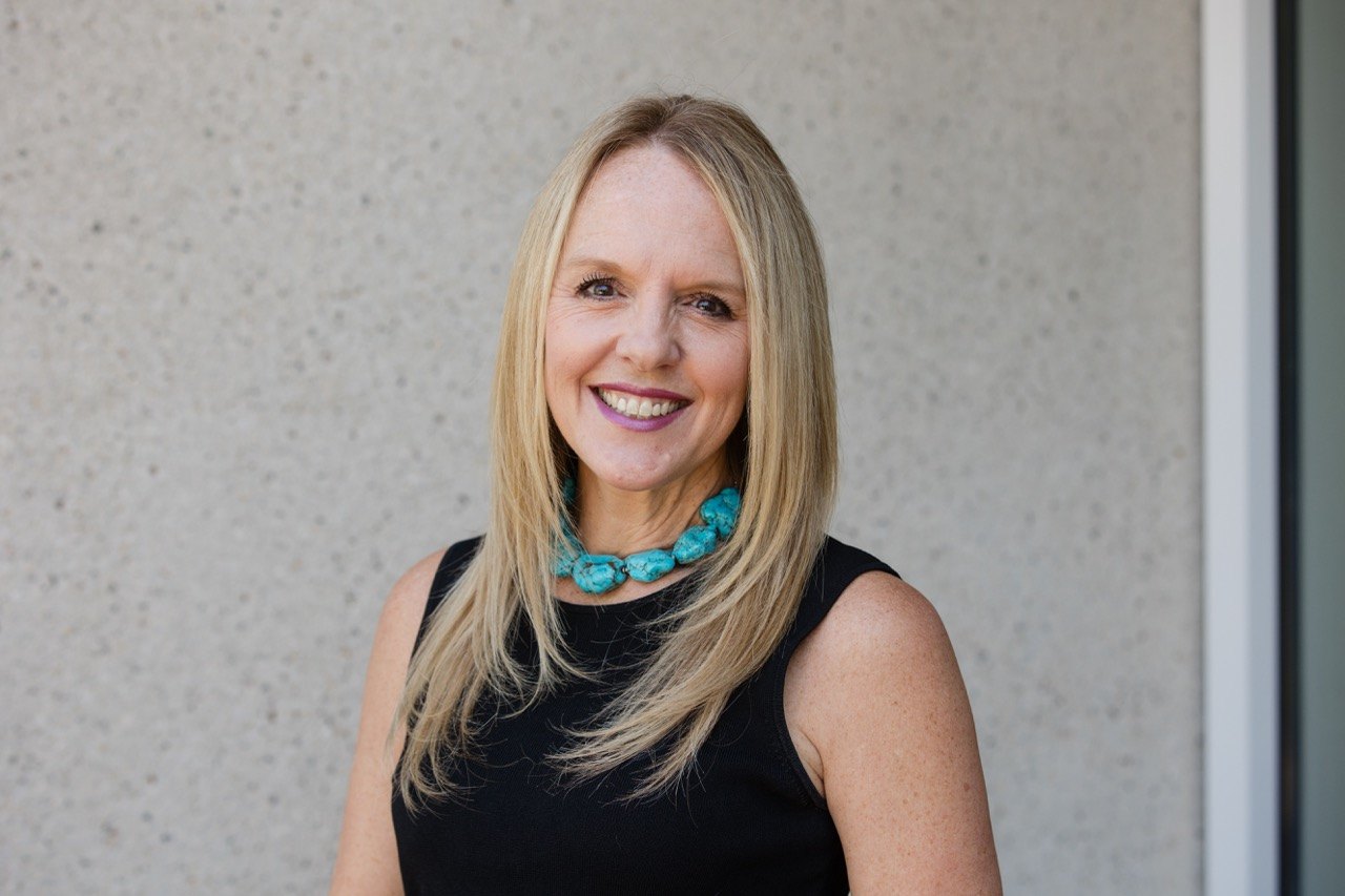 Headshot of a woman with a turquoise necklace