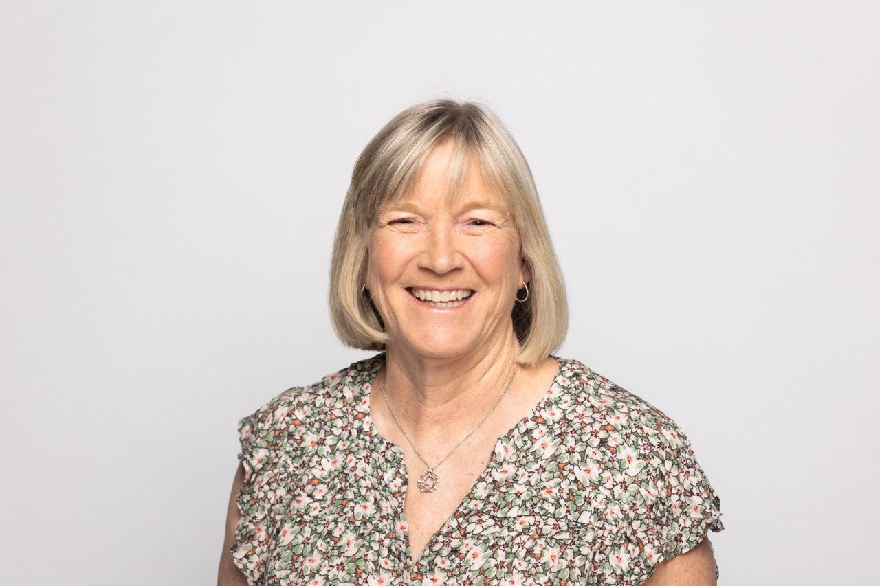 Studio headshot of a woman in a floral top