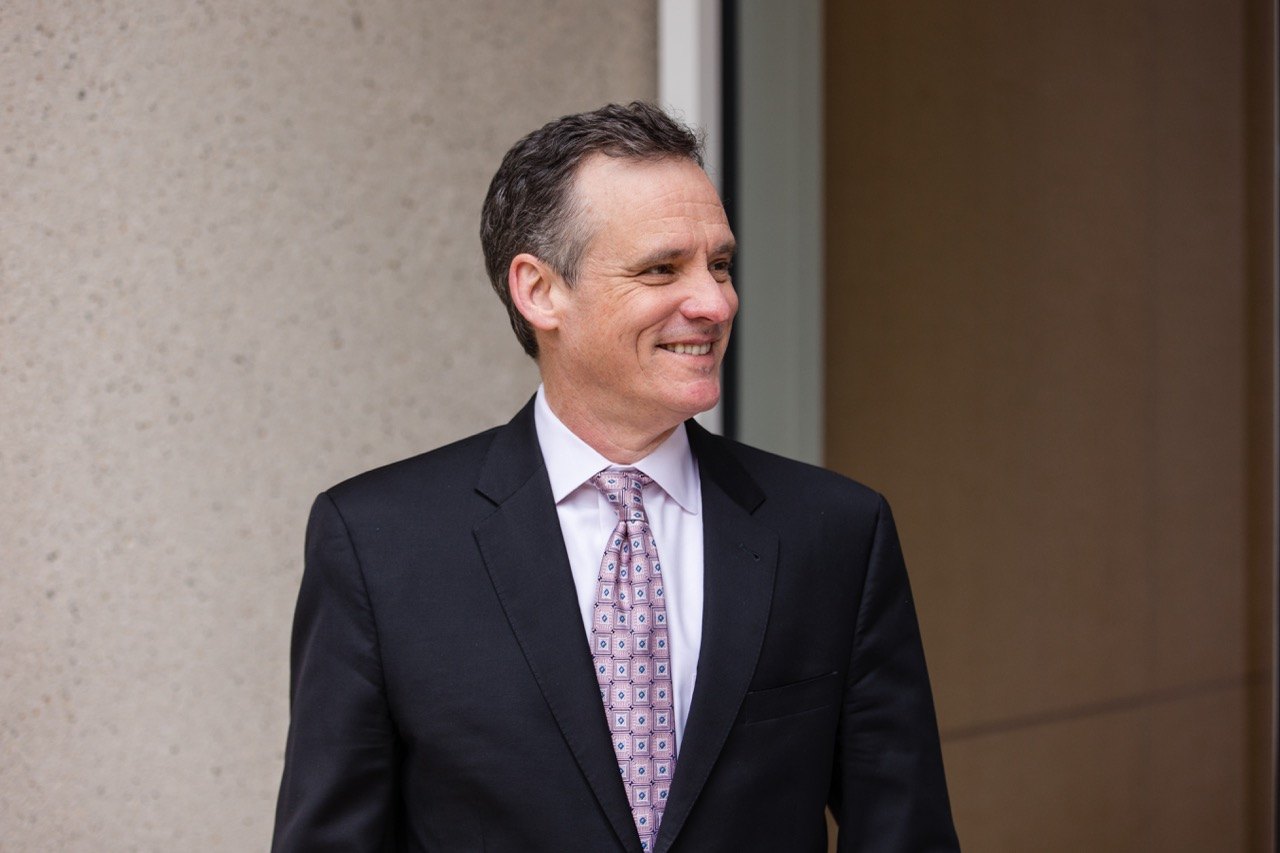 Headshot of a man in a dark suit and tie