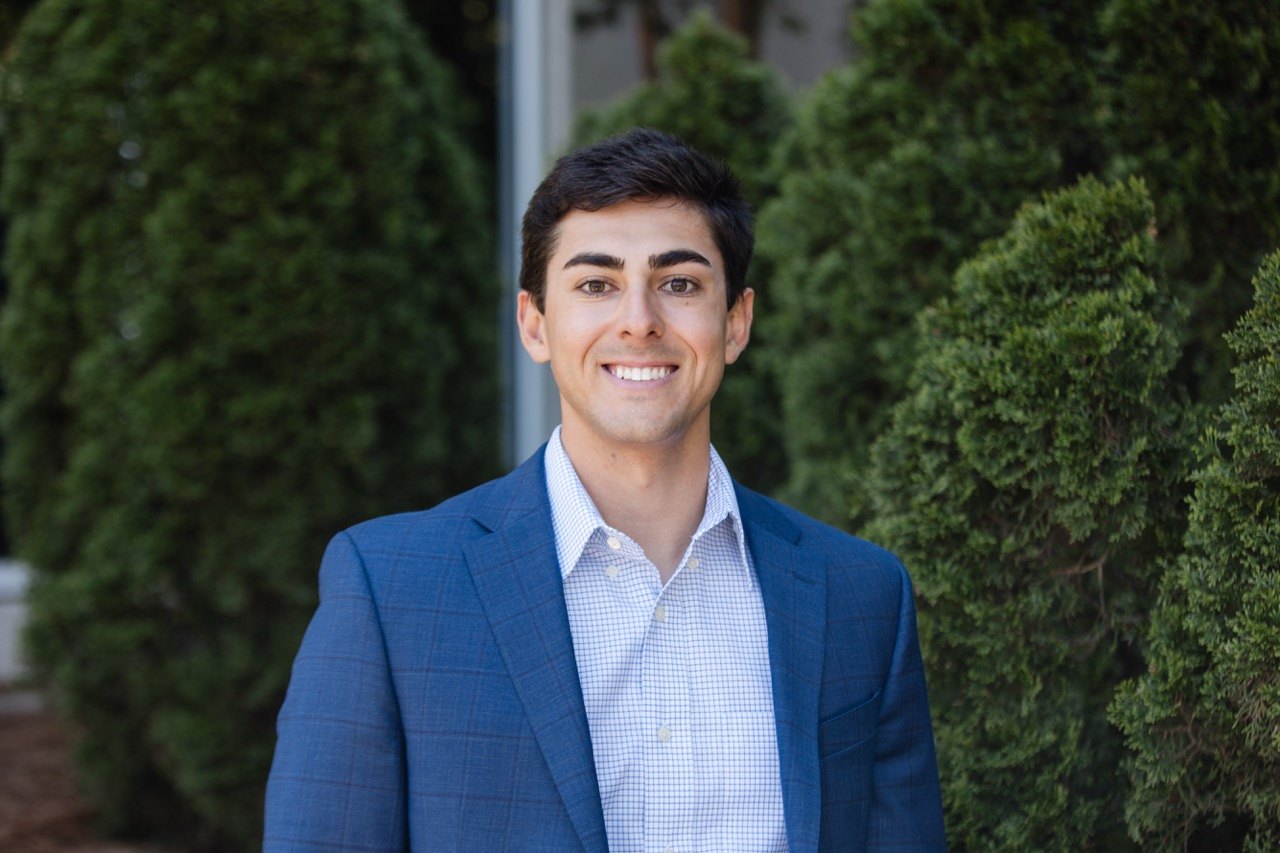 Headshot of a young man in a blue blazer